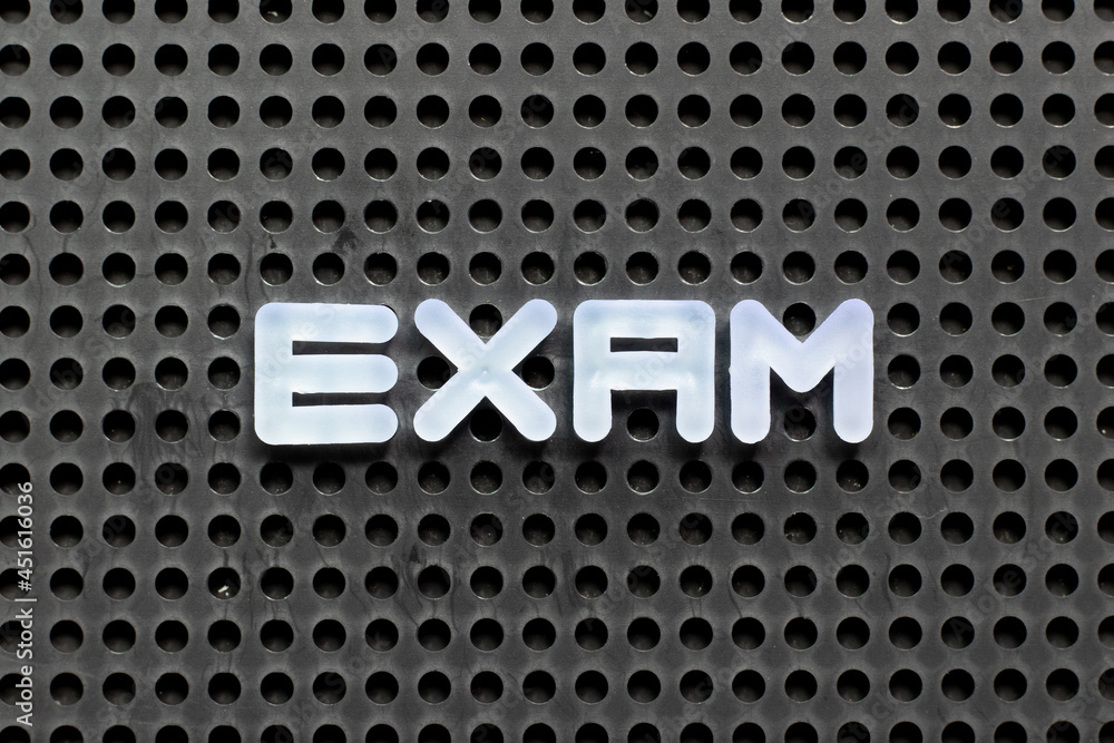 Sticker White color letter in word exam on black pegboard background