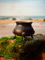 Witch craft cauldron burning ritual on the beach