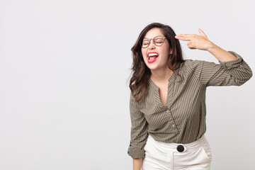 pretty woman looking unhappy and stressed, suicide gesture making gun sign with hand, pointing to...