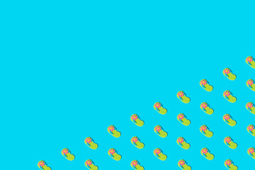 Summer flip flops as pattern on blue background.
