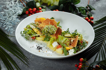 Summer diet salad with leaves of lettuce, watermelon, peach and feta cheese. On a light blue background copy space