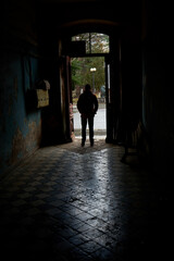 The guy is waiting in the front entrance of the old entrance when the rain stops