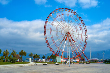 The Ferris wheel is red and white against the sky