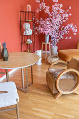 antique vintage interior in 19th century style living room with bright red walls, wood floor and direct sunlight inside the room.