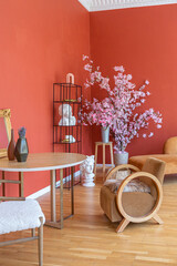 antique vintage interior in 19th century style living room with bright red walls, wood floor and direct sunlight inside the room.