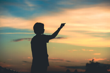 Fototapeta premium young beautiful woman looks hopeful at her hands at sunset.concept success in hand