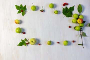 Frame of fresh apples, ripe raspberry and leaves on white background with copy space