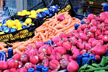 Fresh Organic Turnip and Carrot At A Street Market In Istanbul, Turkey, selective focus. Red radishes as background on the marketplace counter or fruit bazaar. Copy space for your text.