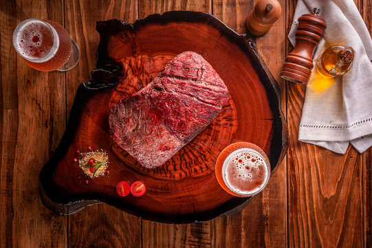 Grilled Denver Steak With Two Glasses Of Beer On Wooden Cutting Board. Marble Meat Beef - Top View.