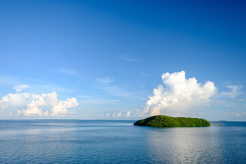 A florida keys atoll in the gulf of mexico at sunrise with large cumulus clouds in the background