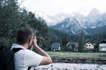 Tourist photographing mountain massif "Spik" of the Triglav national park in Slovenia