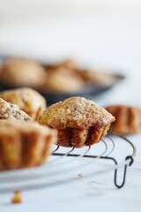 Homemade banana muffins on rustic antique baker's cooling rack  over a white table. Selective focus with blurred foreground and background.