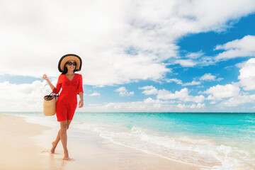 Luxury travel woman walking on perfect white sand Caribbean beach. tourist on summer holiday at...