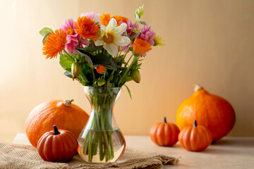 Obraz na płótnie Canvas Autumn beautiful composition with flower bouquet in vase and pumpkins,fall warm backdrop