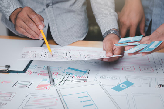 UX or UI designers designing on their smartphone application layout prototype project. - Powered by Adobe