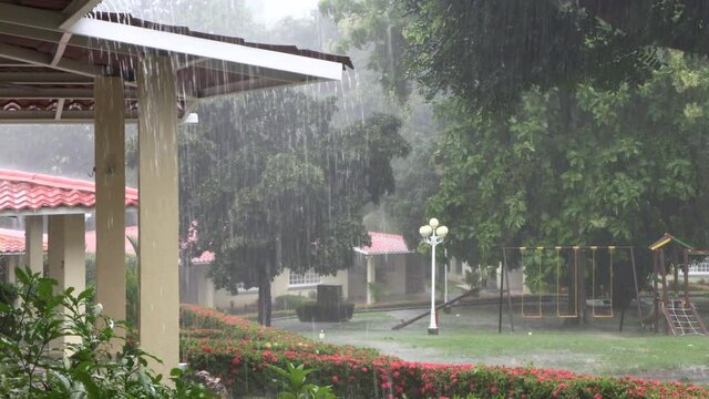 Rain in a residence, rainy season, water falling and flowing from the roof of a house.