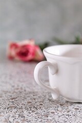 Fototapeta na wymiar Closeup white cup of coffee and pink rose romantic love cute date