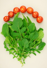  Red cherry tomatoes and green arugula leaves. Healthy or diet food concept, food background. Top view, flat lay.	
