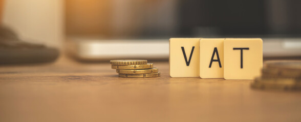 Banner VAT value added tax. Business finance concept with coins and laptop on desktop, copy space...