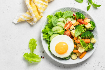 Healthy steamed and raw  vegetables fried egg bowl. Top view, space for text.