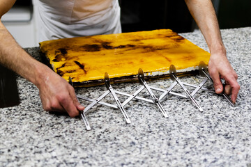 Hands of white male pastry chef hands of haute cuisine pastry design, cutting chocolate, cream and...