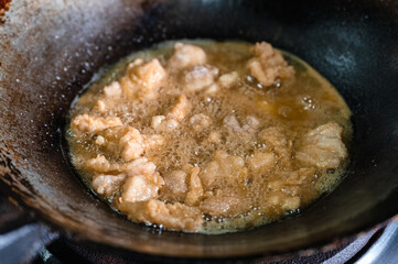 Frying crispy fried chicken meat with boiling oil in fry pan on gas stove