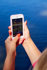 female hands holding a mobile phone for shooting a picture