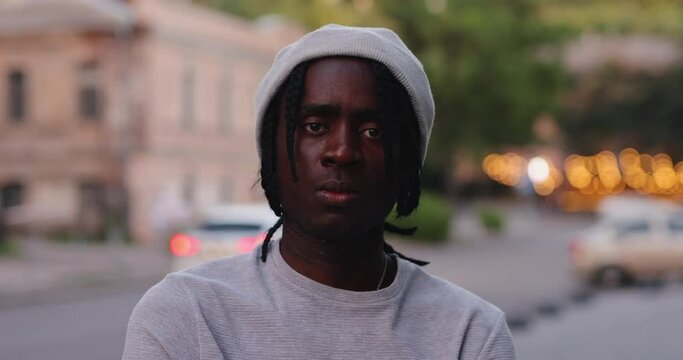 African American man with dreadlocks looking at camera in a city street, slow motion