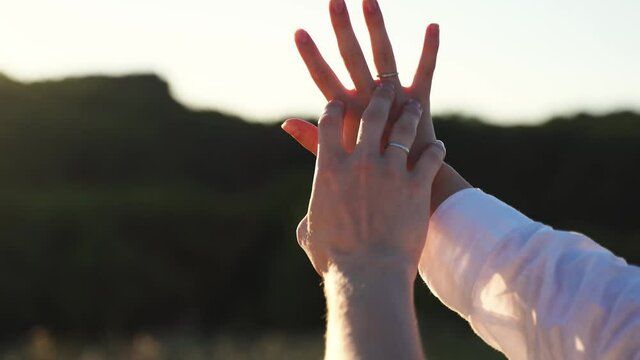 Couple hands together outdoors in sunset light. Young couple romance. Love harmony. Support hands. Handheld video