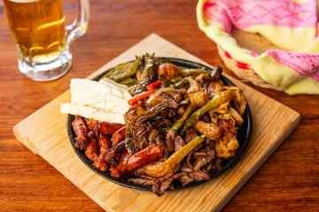 Authentic Mexican barbecue, different cuts roasted on a restaurant table. Chistorra, meat and grilled cheeses. Mexican roast beef concept.