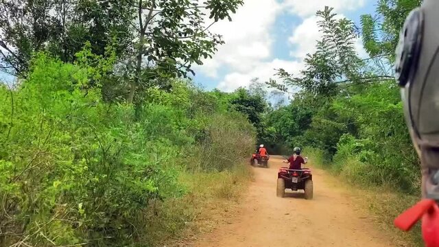 Quad bike ride on a tropical island among trees on a sunny day. Travel and tourism concept