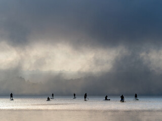 rowers crossing the lake in the morning mist