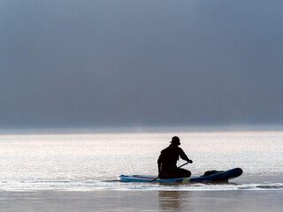 Fototapeta na wymiar rower crossing the lake in the morning mist