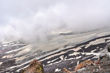 mountain slopes and black volcanic rock covered with snow.