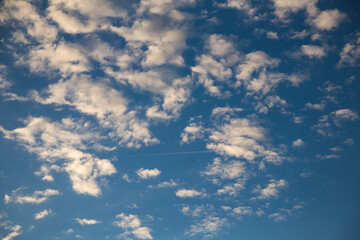 Beautiful blue sky with white fluffy clouds at sunset. Sky panorama for screensavers, postcards,...