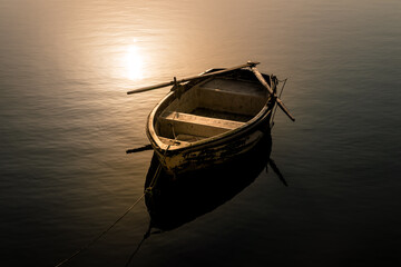 Old fishing boat on the sea at sunset