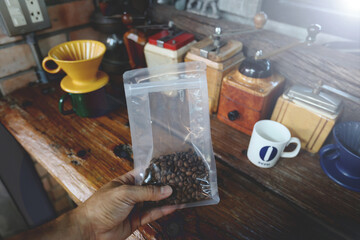 Traditional coffee drink related objects. Roasted Coffee Beans at Plastic  Packaging On Table. background equipment Coffee Grinder Dripper mug cup camera color Retro style.Selective Focus  foreground.