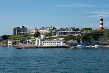 Plymouth, Devon, England, UK. 2021. View of the Plymouth waterfront properties seen from Plymouth Sound viewing Plymouth Hoe, Smeatons Tower and Tinside Lido, leisure area.