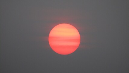 The orange sun in the smoke of forest fires in Yakutia can be viewed with an unarmed eye