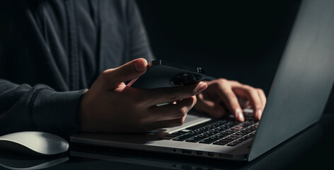 Businessman is working on Smartphone and Laptop. stock business or work from home concept. dark tone