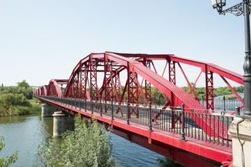 Red iron bridge over Tajo river on a sunny day. Talavera de la Reina, Toledo, Spain, Europe