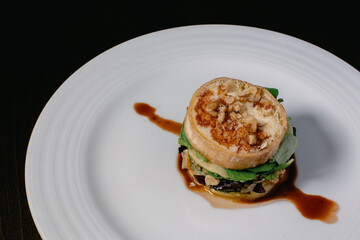 A close-up of a plate with the classic Spanish dish Timbal de Bacalao.  Haute cuisine main course plate.