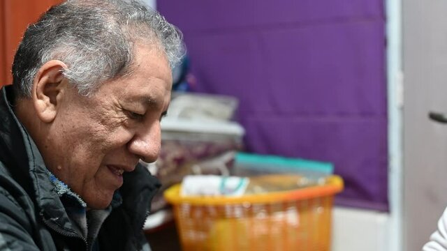 Grandfather and his granddaughter playing and smiling indoors