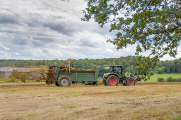 tracteur agricole qui épand le fumier sur le champ