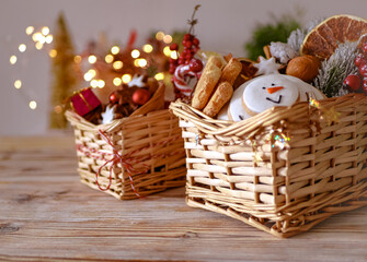 Christmas handmade grocery gifts sweets, honey, lollipops, cookies, new year edible gifts in baskets on a wooden table, copy space, new year food background