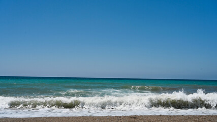 Fototapeta na wymiar Wavy sea on the edge of the beach 