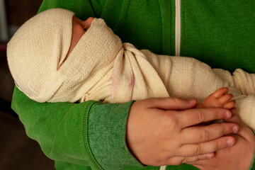 The doll wound on hands at the girl. The concept the baby on hands at mother. Motherhood. close-up