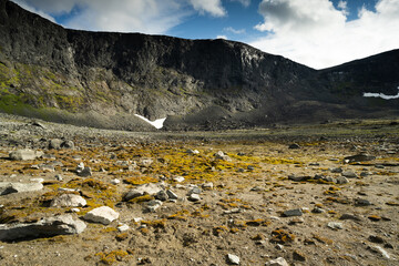 The bottom of a dried mountain lake with stones and moss