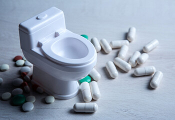 toilet bowl miniature and pills on the table