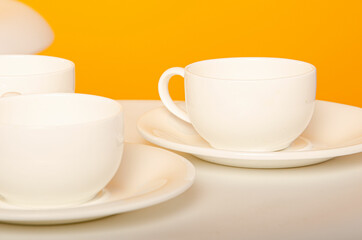 cup on a yellow background. Ceramic mug with saucer for tea or coffee
Place for text
White cup of coffee on a light wooden background. Vintage tones.